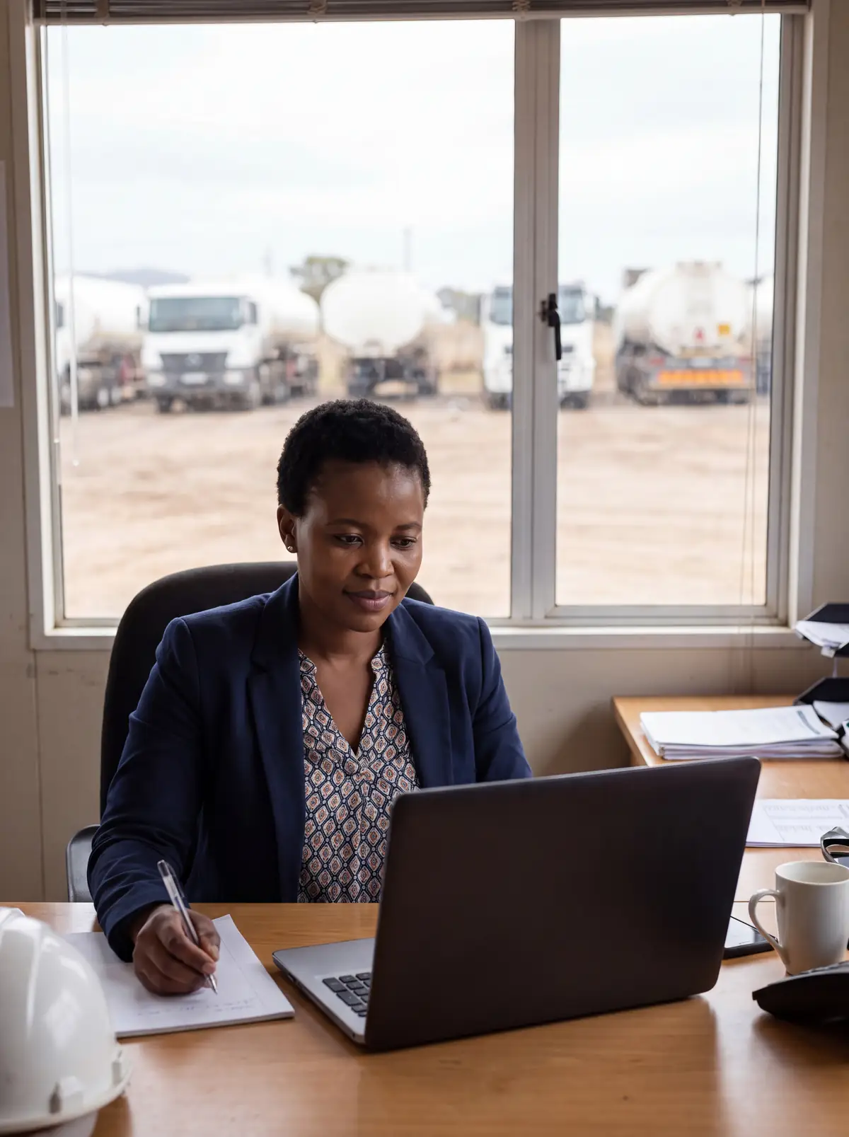 Operations coordinator working at a laptop in a site office